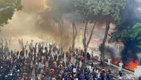 Massa juga melempar petasan hingga membakar motor yang terparkir di dalam gedung. Hal ini menimbulkan asap hitam yang membubung tinggi di lokasi.