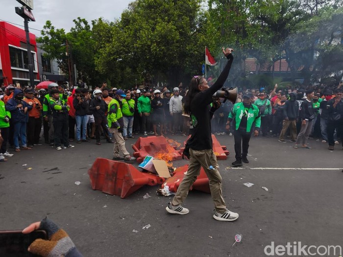 Massa demo di depan Mako Brimob Batalion C Pelopor, Kota Solo, membakar water barrier di Jalan Adi Sucipto, Jumat (29/8/2025).