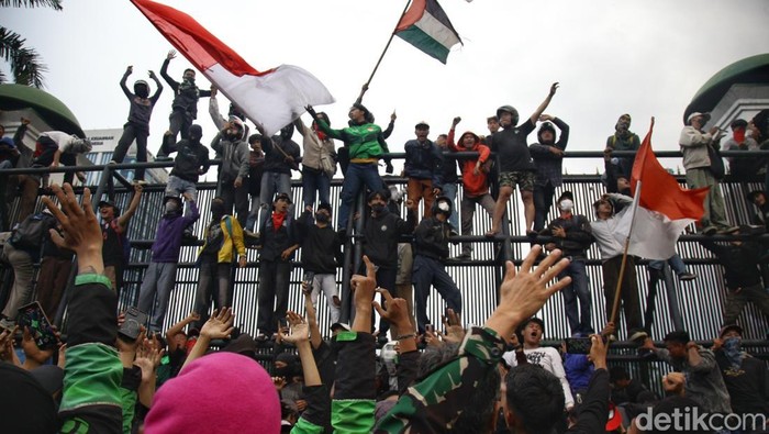 Massa sempat menembus gerbang DPR RI dengan mencopot besi pagar, Jumat (29/8/2025). Sebagian massa yang berhasil masuk ditenangkan anggota TNI dan secara persuasif  meminta para pendemo untuk kembali ke luar pagar. Polisi mundur dan berjarak sekitar 30 meter dari aparat TNI yang berjaga.