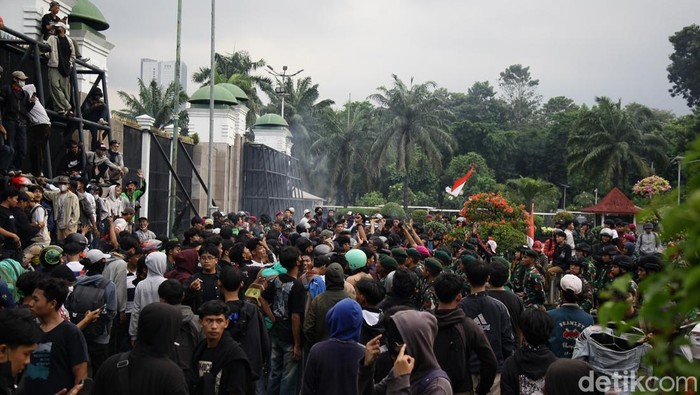 Massa Demo Sempat Jebol Gerbang DPR, Ditenangkan TNI Massa sempat menembus gerbang DPR RI dengan mencopot besi pagar, Jumat (29/8/2025). Sebagian massa yang berhasil masuk ditenangkan anggota TNI dan secara persuasif meminta para pendemo untuk kembali ke luar pagar. Polisi mundur dan berjarak sekitar 30 meter dari aparat TNI yang berjaga.