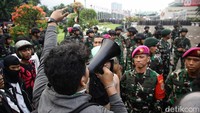 Sebagian massa yang berhasil masuk ditenangkan anggota TNI dan secara persuasif meminta para pendemo untuk kembali ke luar pagar.