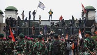Polisi mundur dan berjarak sekitar 30 meter dari aparat TNI yang berjaga.