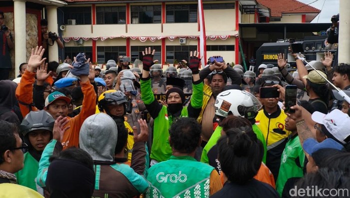 Sejumlah perwakilan ojol mencoba menenangkan peserta aksi di depan Mako Brimob Solo, Jumat (29/8/2025).
