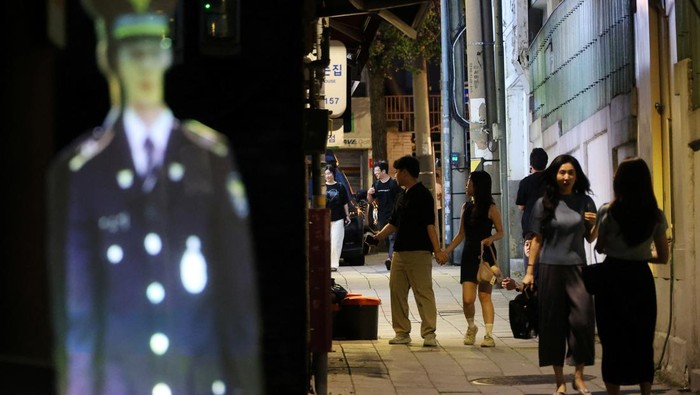 Polisi Virtual Hadir di Seoul, Hologram Ditugaskan Cegah Kriminalitas Korea Selatan mulai mengadopsi teknologi keamanan terbaru dengan menghadirkan petugas polisi holografik di ruang publik. Seorang polisi hologram seukuran manusia kini dipasang di sebuah taman di Seoul pada Kamis (28/8/2025), sebagai bagian dari upaya mencegah kejahatan sekaligus memberikan rasa aman bagi masyarakat. REUTERS/Kim Hong-Ji