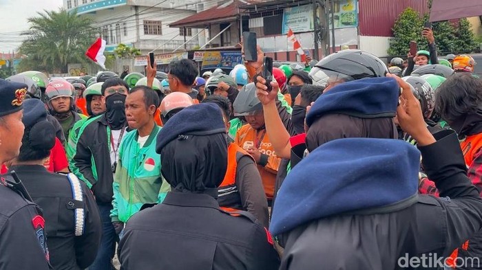 Puluhan pengemudi ojol saat melakukan aksi di depan Brimob Polda Sumut. (Foto: Finta Rahyuni/detikSumut)