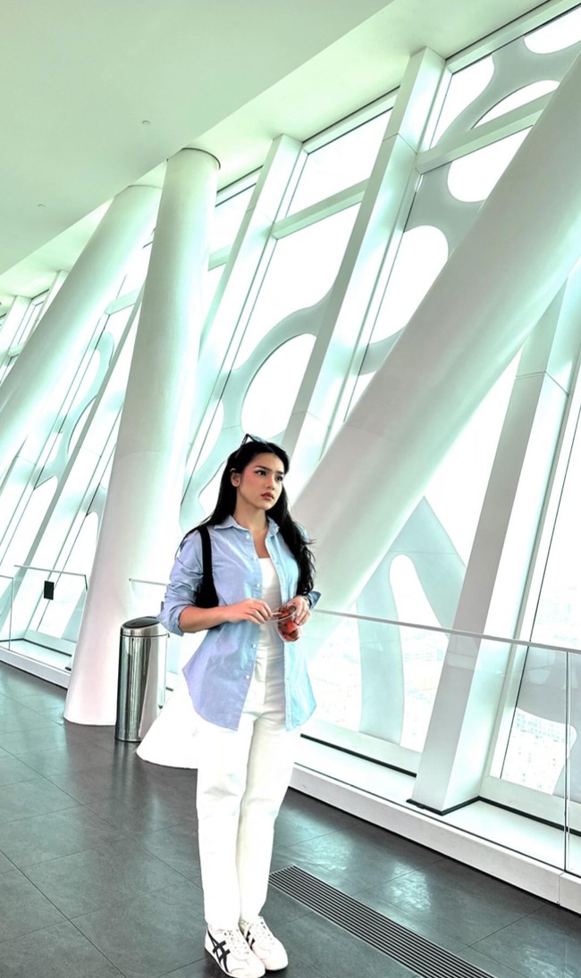 Pada kesempatan lain Davina kembali memilih memadukan kemeja biru muda dengan tanktop dan celana panjang putih. Penampilannya itu terlihat santai namun tetap sopan. Foto: Instagram/@davinaakaramoy