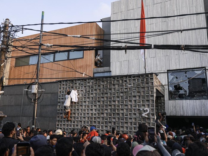 Massa mengeluarkan barang milik anggota DPR Ahmad Sahroni dari dalam rumahnya di kawasan Tanjung Priok, Jakarta, Sabtu (30/8/2025). ANTARA FOTO/Dhemas Reviyanto/sgd