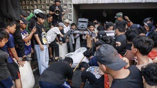 Massa mengeluarkan barang milik anggota DPR Ahmad Sahroni dari dalam rumahnya di kawasan Tanjung Priok, Jakarta, Sabtu (30/8/2025). ANTARA FOTO/Dhemas Reviyanto/sgd