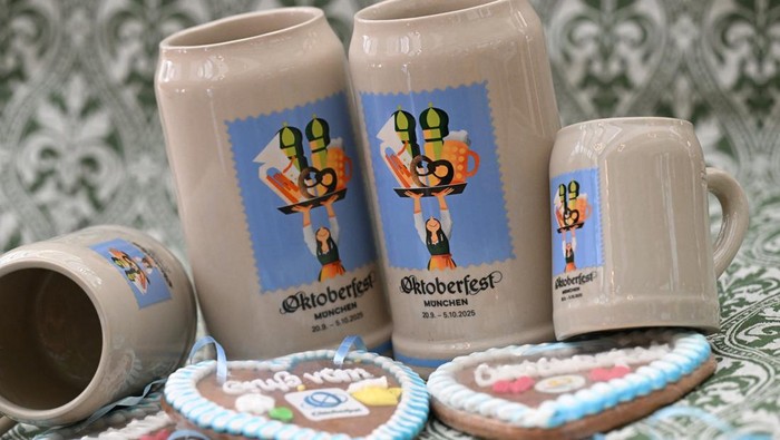 A woman holds the new official Oktoberfest beer mugs during a press event ahead of the Oktoberfest in Munich, Germany, August 28, 2025. REUTERS/Angelika Warmuth