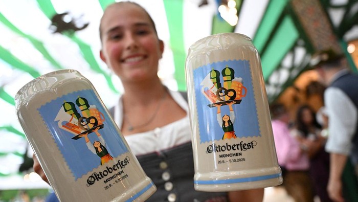 Festival Bir Terbesar Dunia Siap Digelar untuk ke-190 Kalinya A woman holds the new official Oktoberfest beer mugs during a press event ahead of the Oktoberfest in Munich, Germany, August 28, 2025. REUTERS/Angelika Warmuth
