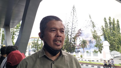 Kepala Bagian Umum dan Humas Sekretariat DPRD NTB, Muhammad Erwan, melihat kobaran api gedung DPRD NTB dari di depan Hotel Prime Park Mataram, Sabtu (30/8/2025). (Ahmad Viqi/detikBali)
