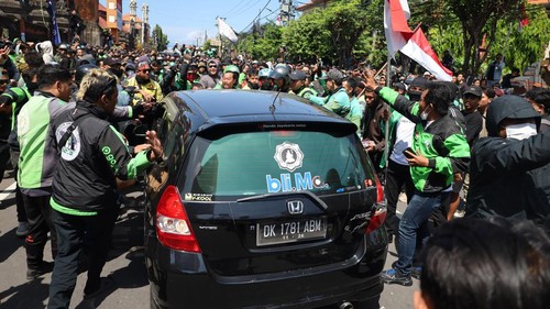 Mobil diadang dan disuruh mundur oleh para pendemo ojek online di depan Mapolda Bali, Sabtu (30/8/2025). (Aryo Mahendro/detikBali)