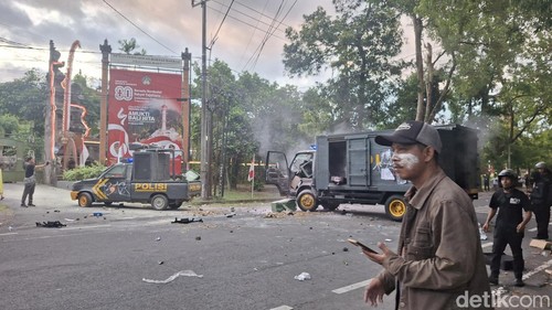 Mobil polisi dirusak massa di depan Gedung DPRD Bali, Sabtu (30/8/2025).