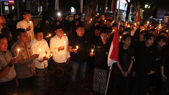 Mahasiswa menggelar doa bersama dan menyalakan lilin di Polres Kudus, Jumat (29/8/2025) malam.