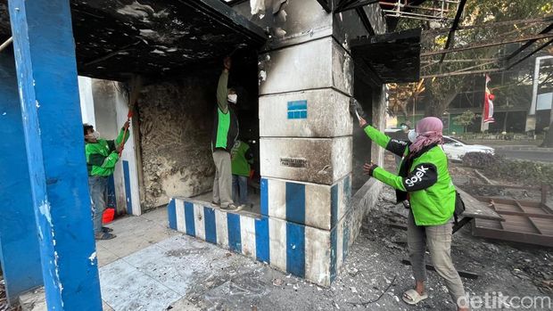 Ojol dan warga bersihkan pos polisi yang sempat dibakar di Surabaya