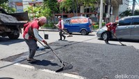 Petugas juga melakukan pengaspalan  jalan yang rusak.
