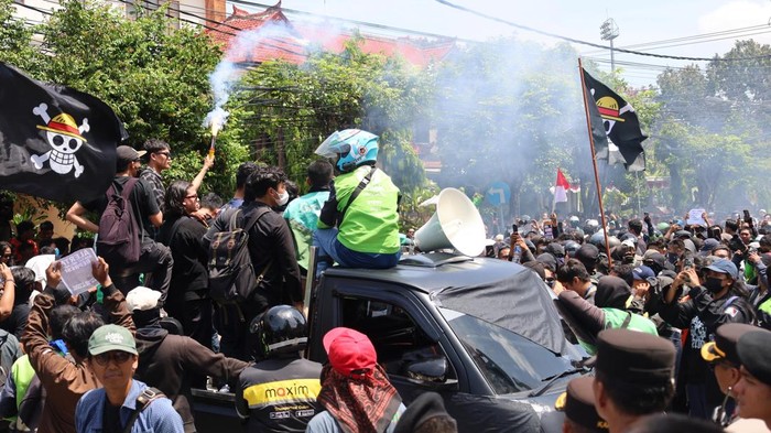 Pendemo nyalakan flare di atas bak mobil pikap di depan Mapolda Bali, Sabtu (30/8/2025). (Aryo Mahendro/detikBali). (Aryo Mahendro/detikBali)