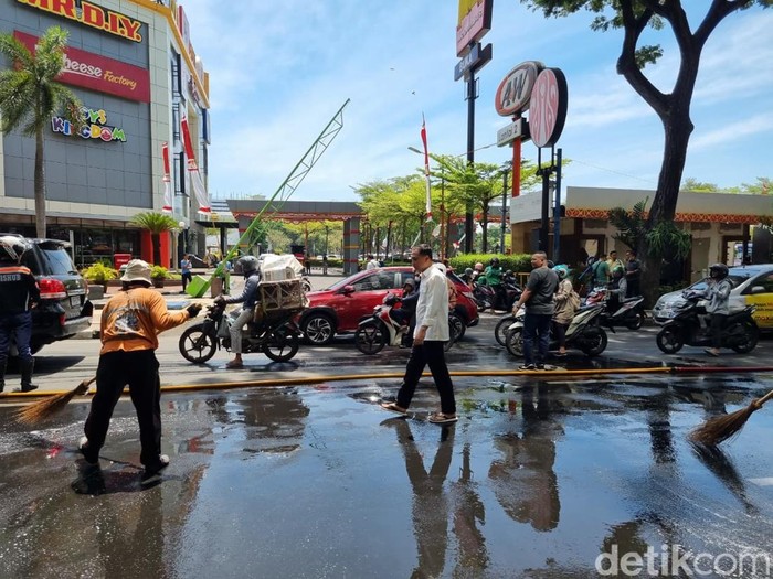 Petugas Gabungan Membersihkan Jalan di Kota Surabaya