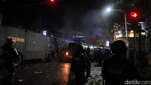 Puluhan personel Brimob masih bersiaga di Perempatan Jalan Puputan-Jalan Kusuma Atmaja sambil mengawasi massa yang bertahan di Jalan Tukad Unda, Sabtu (30/8/2025).