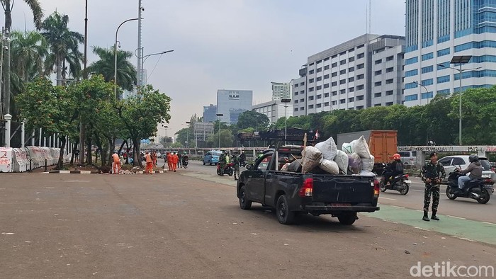 Sejumlah petugas PPSU bersihkan sampah sisa demo di depan Gedung DPR, Jakarta Selatan.