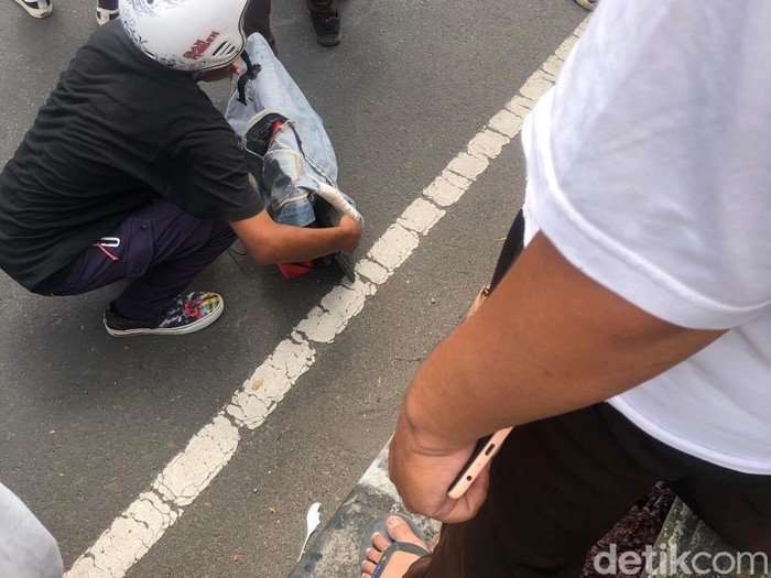 Seorang pendemo mengambil komputer dari Gedung DPRD NTB yang dibakar massa