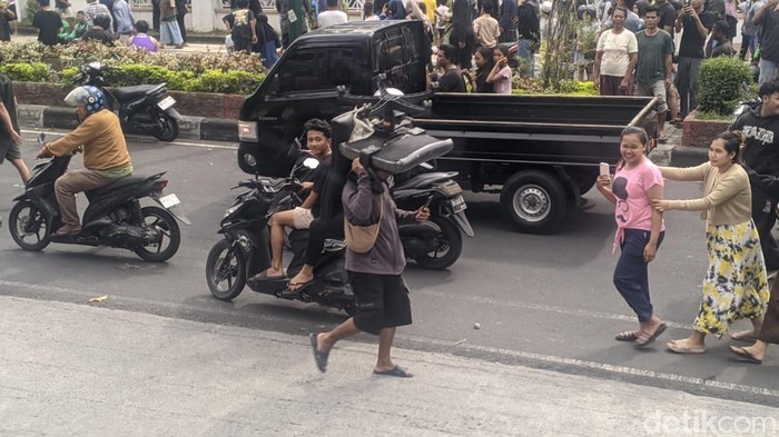 Seorang pendemo terlihat memikul kursi kantor yang diambil dari Gedung DPRD NTB
