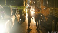 Para sopir yang jenuh di dalam truk keluar mobil dan ngobrol dengan sopir lainnya.