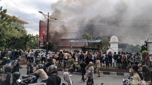 Warga masih berkerumun di depan gedung DPRD NTB yang ludes terbakar oleh massa aksi, Sabtu sore (30/8/2025).