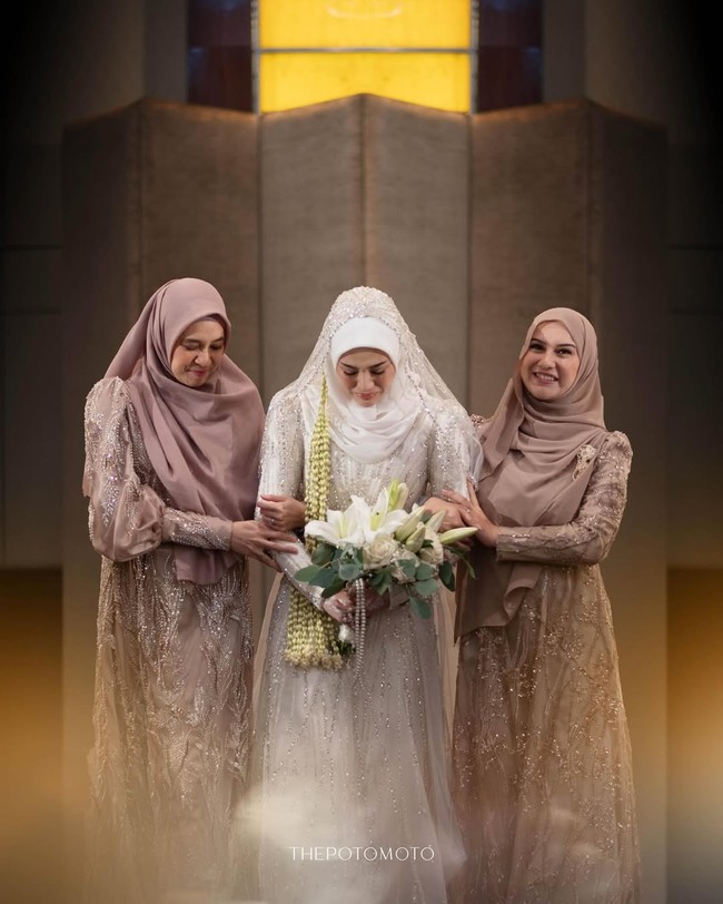 Clara Shinta tak bisa membendung tangisnya saat berjalan ke pelaminan didampingi dua sahabat dekatnya, Irish Bella dan Dhini Aminarti. Kedua aktris terlihat kompak sebagai bridesmaid dan larut dalam kebahagiaan Clara. Foto: dok. Instagram @thepotomoto