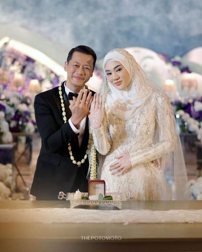 Pasangan suami istri baru ini tampak berbahagia saat memamerkan cincin pernikahannya. Lxa tampil gagah dalam balutan setelan jas hitam SAS Designs, sementara Clara memancarkan aura elegan dan anggun di sampingnya. Foto: dok. Instagram @thepotomoto