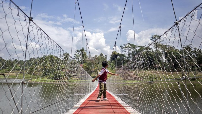 Seorang anak berjalan di atas Jembatan Gantung Sungai Cicadas di Desa Karanganyar, Cililin, Kabupaten Bandung Barat, Jawa Barat, Minggu (31/8/2025). Vertical Rescue Indonesia (VRI) membangun jembatan gantung sepanjang 120 meter yang menghubungkan Desa Karanganyar, Kecamatan Cililin dengan Desa Suka Mulya, Kecamatan Cipongkor guna mempermudah masyarakat yang selama ini kesulitan mengakses layanan pendidikan, ekonomi, kesehatan, hingga administrasi kependudukan akibat kondisi geografis yang terisolasi. ANTARA FOTO/Abdan Syakura/foc.