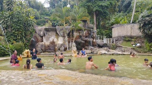 Sejumlah wisatawan berendam di kolam air panas Espa Yeh Panas, Tabanan, Bali, Minggu (24/8/2025).