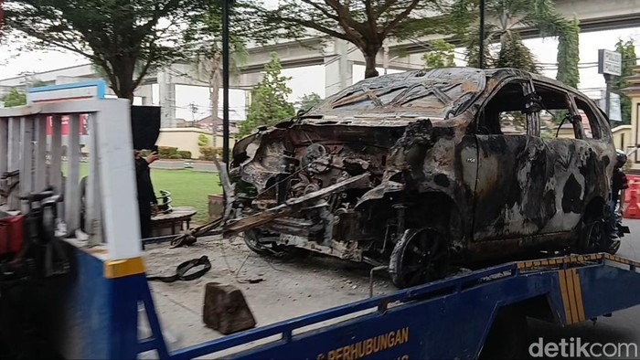 Penampakan mobil yang hangus terbakar di dekat salah satu pos polisi container Palembang akibat aksi perusuh,