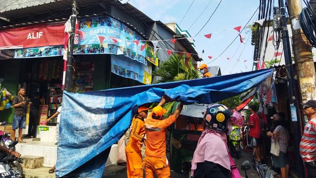 Petugas PPSU bantu angkut puing sisa penjarahan rumah Sahroni (Kurniawan/detikcom)