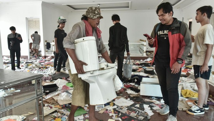 Sejumlah massa tidak dikenal membawa barang-barang di rumah Anggota DPR Surya Utama atau Uya Kuya di Pondok Bambu, Jakarta Timur, Minggu (31/8/2025). ANTARA FOTO/Fakhri Hermansyah/foc.