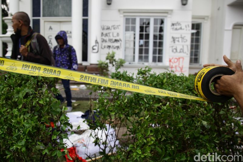 Petugas kepolisian memasang garis polisi di sekitar rumah anggota DPR RI Surya Utama alias Uya Kuya di Pondok Bambu, Jakarta Timur, Minggu (31/8/2025). Penjagaan ini dilakukan untuk membatasi akses dan menjaga keamanan area setelah terjadi penjarahan oleh massa.