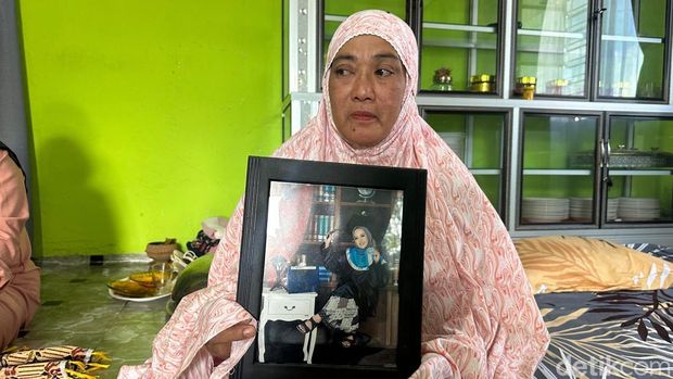 Hatimang memegang foto mendiang putri semata wayangnya, Sarina Wati, korban tewas saat pembakaran gedung DPRD Makassar oleh massa aksi.