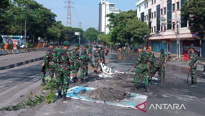 Sejumlah petugas saat membersihkan jalan di kawasan Mako Brimob Kwitang Jakarta, Minggu (31/8/2025).