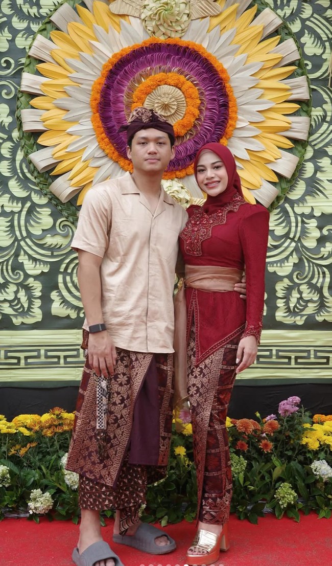 Ia menambahkan selendang kain organza warna cokelat muda yang diikat dengan bros emas di pinggang, memberi sentuhan formal khas kebaya Bali. Bros berbentuk bunga dengan detail cantik dipakai untuk mengikat selendang, sekaligus menambah nuansa mewah pada keseluruhan tampilan. Foto: Instagram/@aurelie.hermansyah