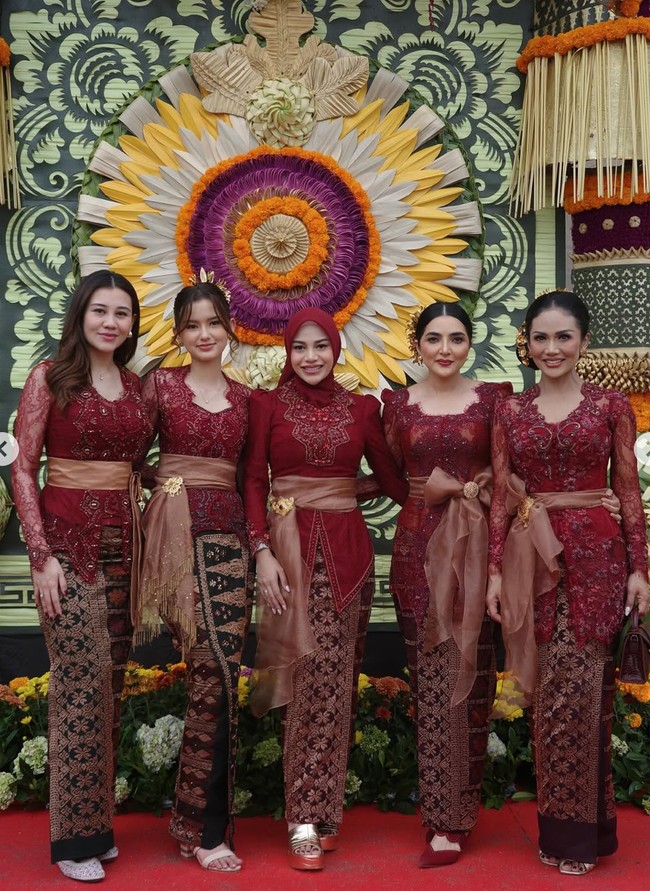 Penampilan Aurel seragaman dengan anggota keluarganya. Dalam foto terlihat KD, Ashanty, Sarah Menzel, hingga Aaliyah yang juga kompak kenakan kebaya Bali warna merah marun. Foto: Instagram/@aurelie.hermansyah