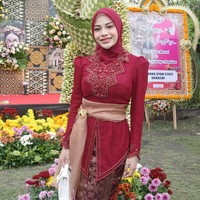 Sebagai pelengkap, ia membawa handbag kecil warna putih dengan tekstur elegan, yang memberi kontras manis pada outfit dominan merah dan cokelat. Untuk alas kakinya Aurel mengenakan heels warna emas metalik, yang menambah tinggi badan sekaligus menonjolkan kesan glamor. Foto: Instagram/@aurelie.hermansyah