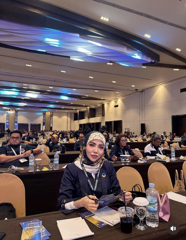 Selama menjadi anggota DPRD gaya Bella selalu terlihat stylish dan sopan. Sepeerti gayanya saat mengikuti Rakernas di Makassar, Sulawesi. Ia memadukan hijab bercorak dengan blazer biru tua. Foto: Instagram/@bellashofie_rigan