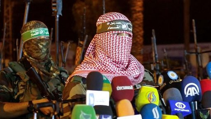 (FILES) Abu Obeida (R), spokesman for the armed wing of Hamas, the Ezzedine al-Qassam Brigades, delivers a statement in Gaza City late on July 8, 2015. Israeli Prime Minister Benjamin Netanyahu said on August 31 that Israel had carried out a strike on Abu Obeida. (Photo by Mohammed ABED / AFP)