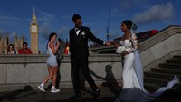 Sepasang kekasih pun memanfaatkan momen indah dengan berpose untuk foto pernikahan, menjadikan Big Ben sebagai latar romantis yang penuh makna. REUTERS/Hannah McKay