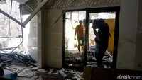 Dua anggota polisi sedang melintasi di ruangan membawa baraang-barang yang terselamatkan di Polsek Tegalsari.