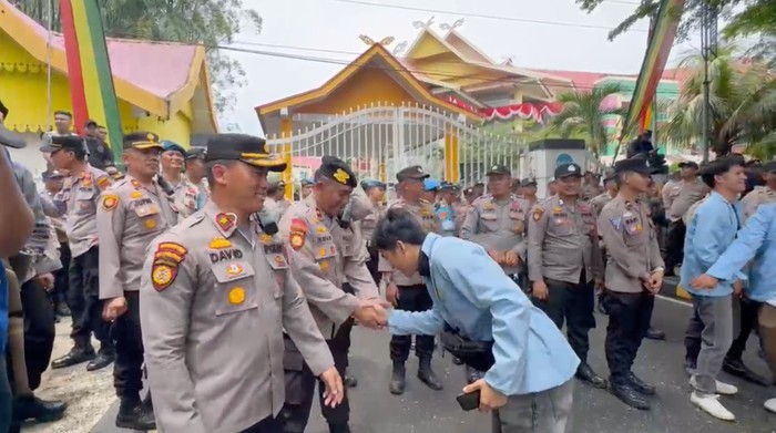 Mahasiswa di Riau menyalami polisi usai menggelar aksi damai di depan gedung DPRD Provinsi Riau, Senin (1/9/2025).
