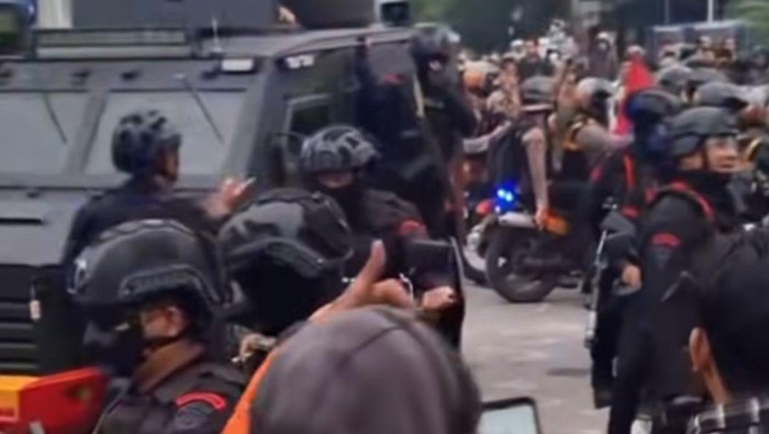 Massa aksi saat saling berjabat tangan dengan personel brimob. (dok. Istimewa)