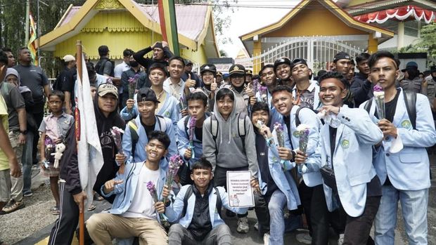 Polwan Polda Riau membagikan bunga kepada mahasiswa pendemo di momen HUT ke-77, Senin (1/9/2025).