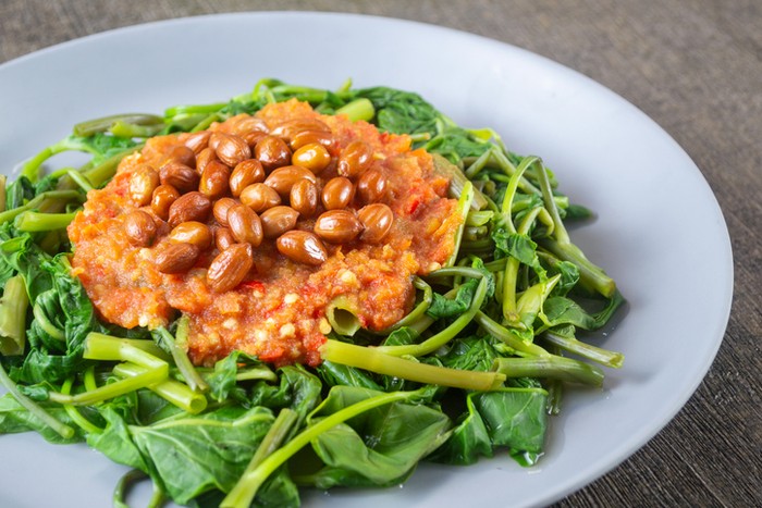Plecing Kangkung is a refreshing and spicy Indonesian salad made from blanched water spinach (kangkung) topped with a flavorful chili sambal. Originating from Lombok