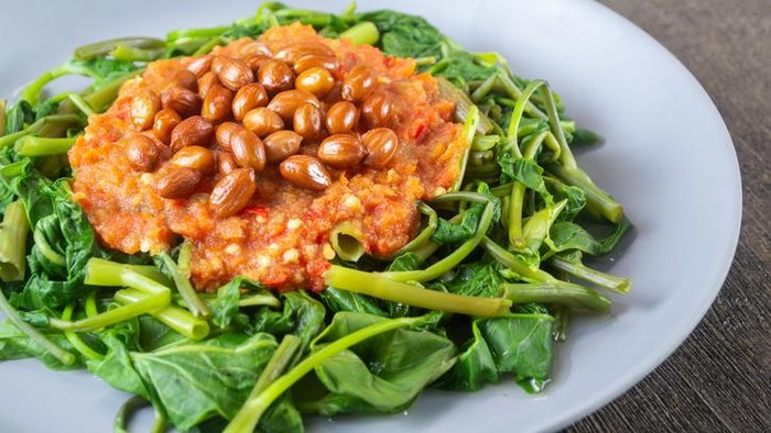 Plecing Kangkung is a refreshing and spicy Indonesian salad made from blanched water spinach (kangkung) topped with a flavorful chili sambal. Originating from Lombok